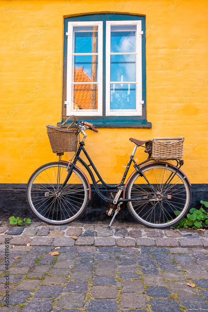 Bicycle parked near yellow wall of an old house in a classical traditional European village.