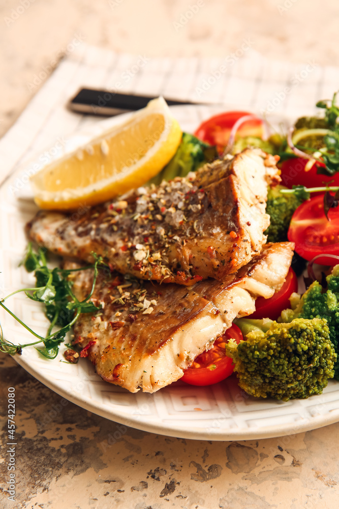 Plate with tasty baked cod fillet and vegetables on color background, closeup Plate with tasty baked cod fillet and vegetables on color background, closeup
