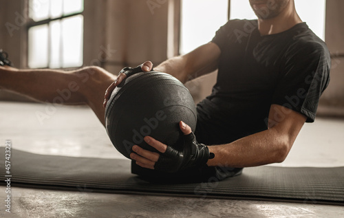 Man doing abs exercise with medicine ball photo
