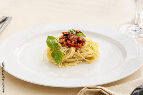 Plate with tasty Pasta Puttanesca on table in restaurant