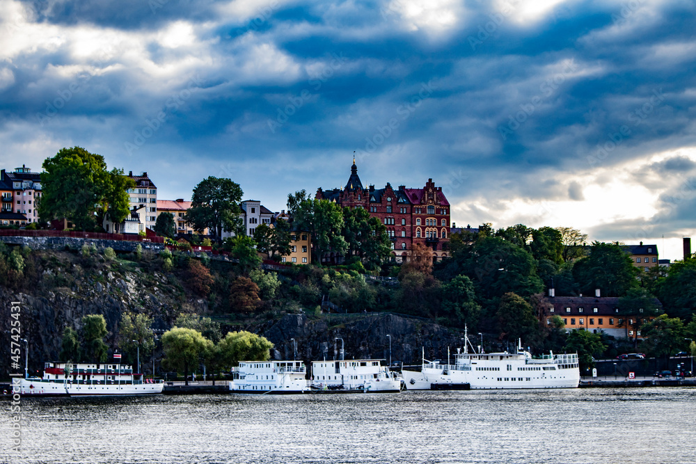 Naklejka premium Boats and Traditional Buildings Line the Rocky Cliffs of the Katarina-Sofia Island Coastline in Stockholm, Sweden