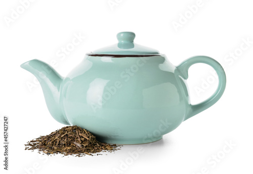 Tea pot and pile of dry hojicha green tea on white background