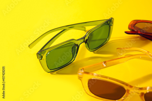 Different female sunglasses on color background