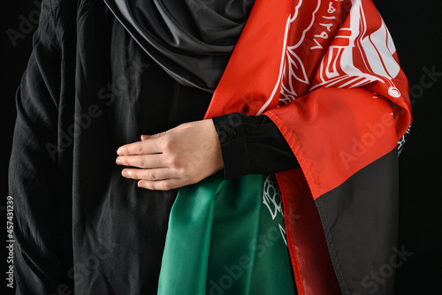 Woman with flag of Afghanistan on dark background