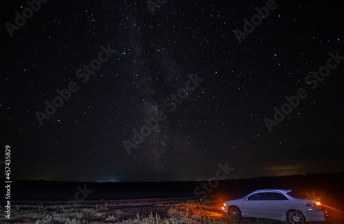 car and the milky way in the field at night