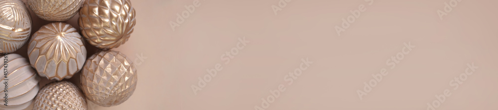 Christmas banner.beige christmas decorative balls on a beige background.Festive christmas background in sand golden tones.Beige textured background.Festive banner Christmas banner.beige christmas decorative balls on a beige background.Festive christmas background in sand golden tones.Beige textured background.Festive banner