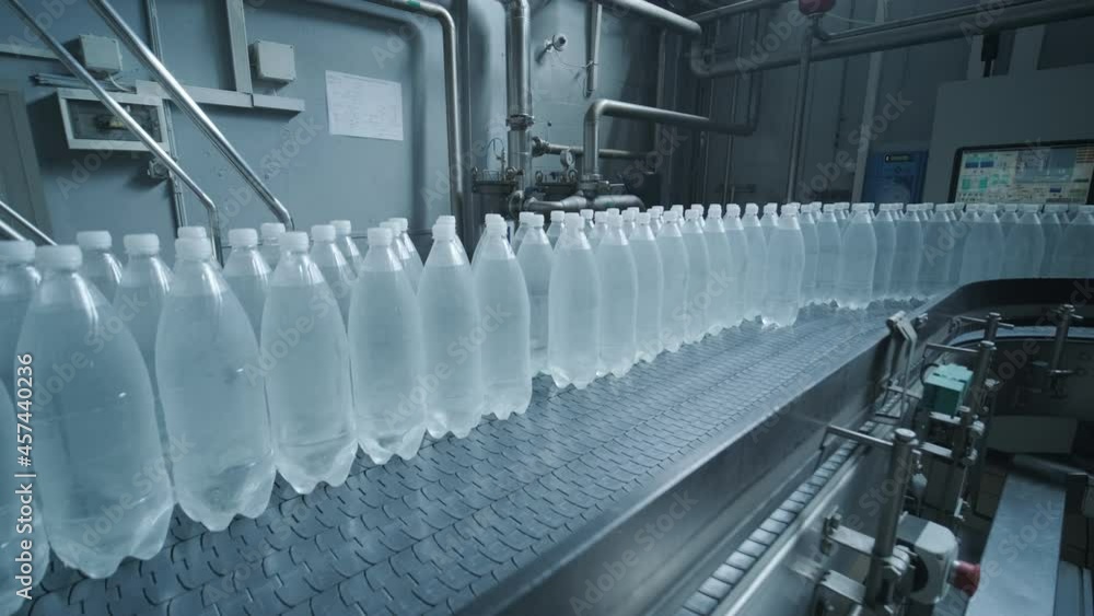 Conveyor belt with bottles of drinking water at a modern beverage plant Conveyor belt with bottles of drinking water at a modern beverage plant