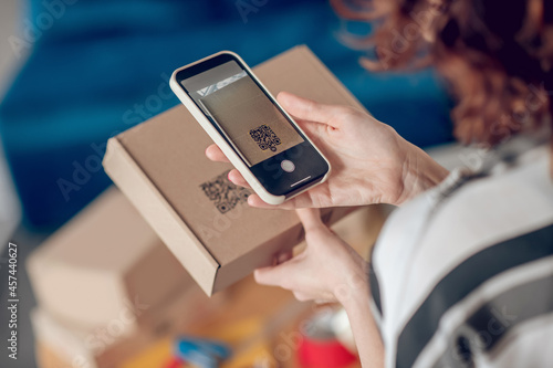 Online shop worker scanning information on the product package