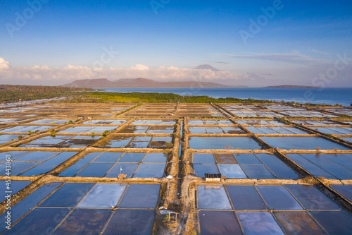 Aerial drone view of large salt fields located on the northern coast of Bali in Pemuteran coastal town to be precise and situated near the ocean to collect the water from the sea.