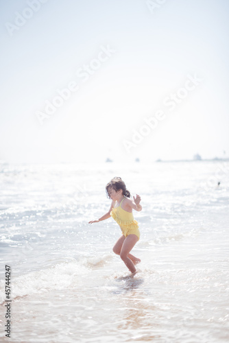 child playing on the beach in ocean on sunny day
