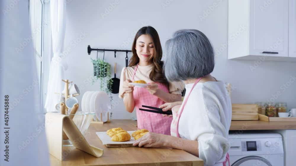 Asian lovely family, young daughter look to old mother cook in kitchen Asian lovely family, young daughter look to old mother cook in kitchen