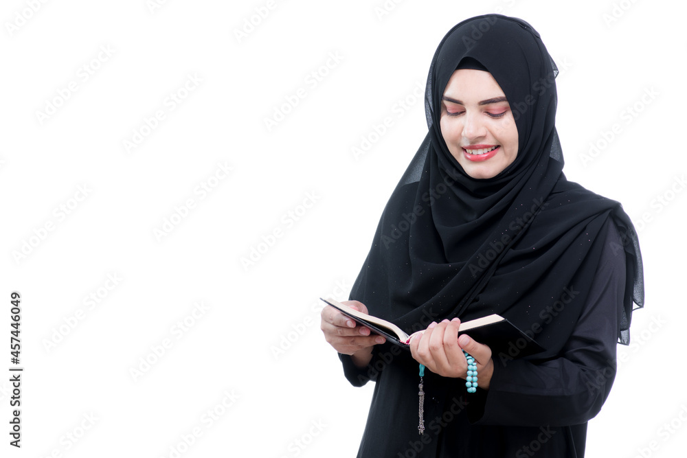Portrait Asian Muslim woman standing and reading the Quran and appreciates and faith The Holy Al Quran with written Arabic calligraphy meaning of Al Quran, Arabic word translation : The Holy Al Quran. Portrait Asian Muslim woman standing and reading the Quran and appreciates and faith The Holy Al Quran with written Arabic calligraphy meaning of Al Quran, Arabic word translation : The Holy Al Quran.