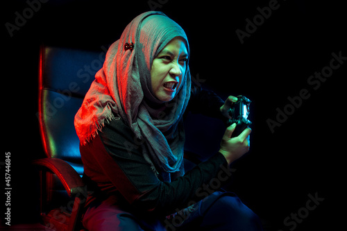 Asian Muslim mothers playing console games with funny faces.