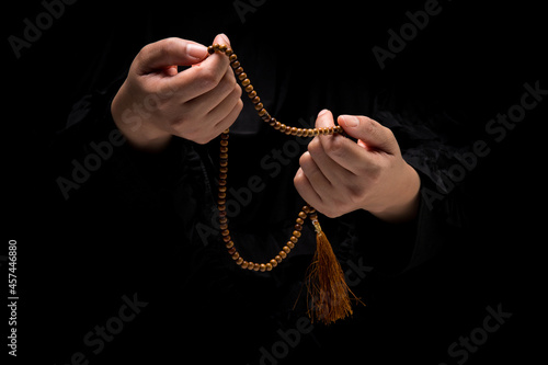The image of a Muslim woman's hand, Islamic prayer, and her hand holding a rosary bead or tasbih.