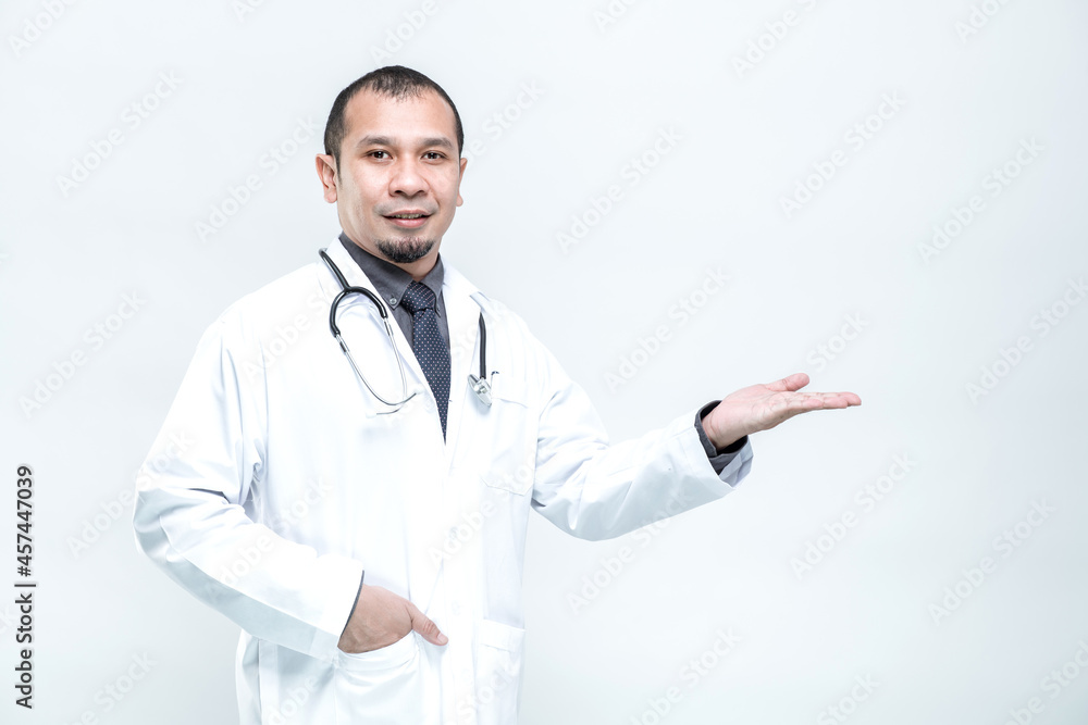 Portrait of a cheerful smiling man doctor showing and presenting something with hand on white background. Portrait of a cheerful smiling man doctor showing and presenting something with hand on white background.
