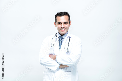 Portrait of cheerful smiling man doctor with arms crossed on white background.