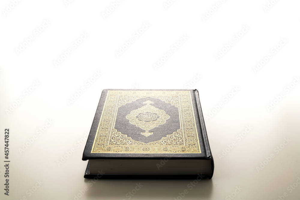 Islamic concept - The Holy Al Quran with written Arabic calligraphy meaning of Al Quran, Arabic word translation: The Holy Al Quran (holy book of Muslim), on white background, with copy space.