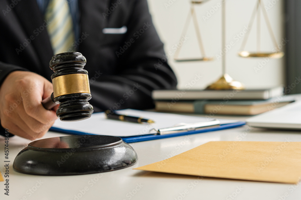 Judge and prosecutor's hammer businessman in suits works with laptop, hammer and femida in the office of paperwork, law, advice and justice concepts. Judge and prosecutor's hammer businessman in suits works with laptop, hammer and femida in the office of paperwork, law, advice and justice concepts.