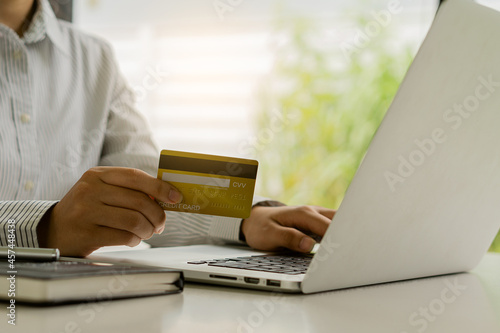 woman holding credit card and using laptop to work business people or entrepreneurs working, online shopping, ecommerce, concept internet banking, money spending, taxes