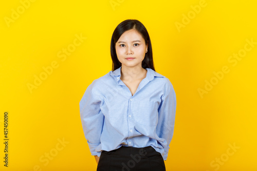 Portrait of young and cute Chinese, Japanese style  woman pose to camera with positive gesture and friendly smile on yellow camera