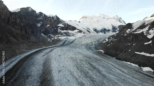 Aerial flyover over Corbassiere glacier in Valais, Switzerland at sunrise photo