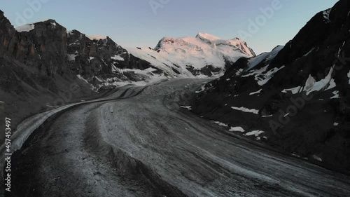 Aerial flyover over Corbassiere glacier in Valais, Switzerland at dusk photo