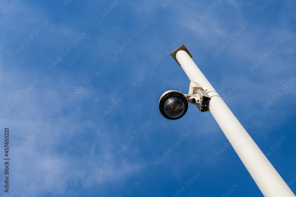 Street surveillance camera on a white metal pole