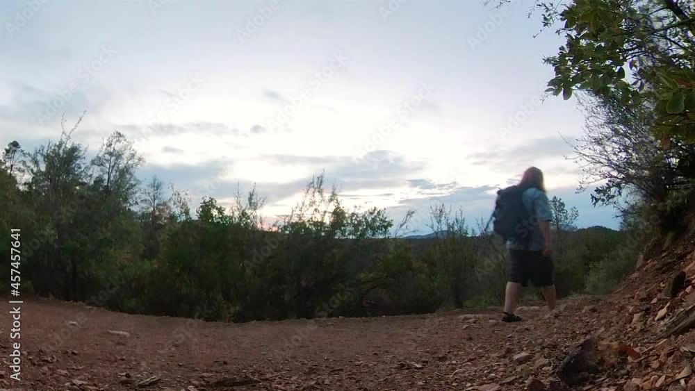 A hiker walks down a trail during sunset near Prescott A hiker walks down a trail during sunset near Prescott