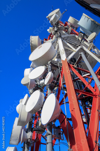 telecommunications tower of different mobile phone, radio and television operators with masts and microwave radio link antennas, 4g and deployment of 5g generation in cities and rural areas 