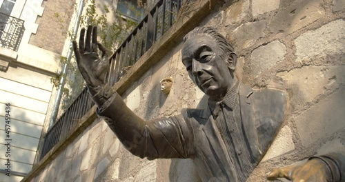 Close up passe muraille, Montmartre, Paris. Statue of a man stuck through a wall, inspired from Marcel Ayme novel. France