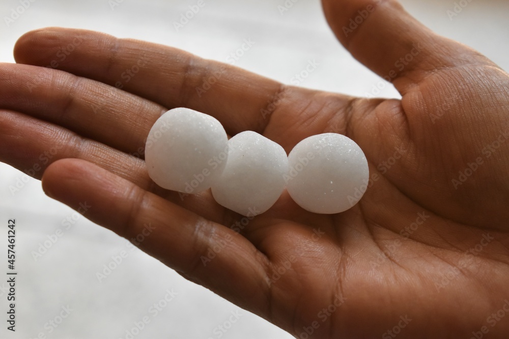 White naphthalene balls in hand White naphthalene balls in hand