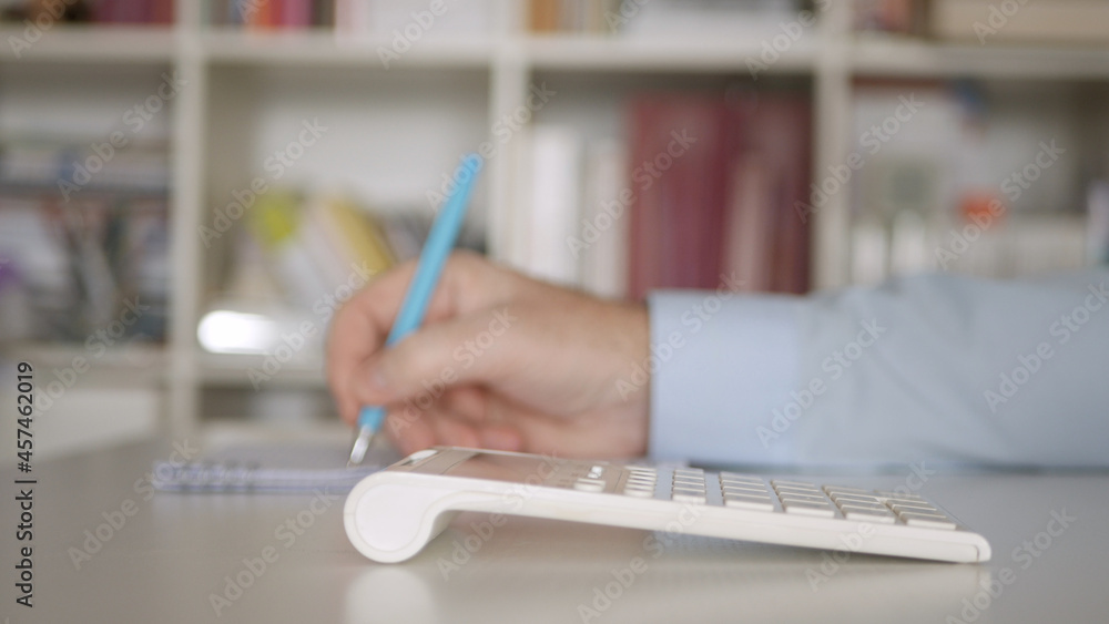 Businessman Working with Invoices, Makes Financial Calculations with Adding Machine. Accounting Fee and Taxes Calculations. Businessman Working with Invoices, Makes Financial Calculations with Adding Machine. Accounting Fee and Taxes Calculations.