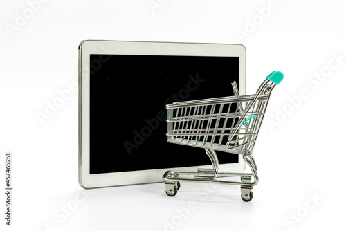 mini shopping cart and digital tablet with black screen isolated on white, online shopping concept photo