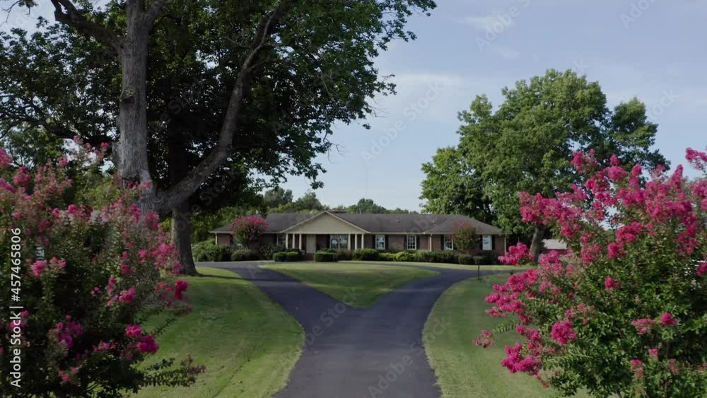 4K aerial pushing in past pink bushes up drive to idyllic southern farmhouse 4K aerial pushing in past pink bushes up drive to idyllic southern farmhouse