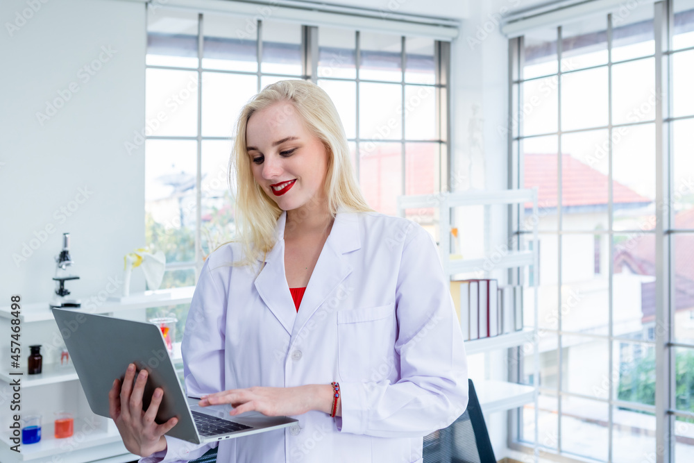 portrait of a female researcher carrying working with laptop computer and out research in a chemistry lab scientist holding test tube with sample in Laboratory analysis background portrait of a female researcher carrying working with laptop computer and out research in a chemistry lab scientist holding test tube with sample in Laboratory analysis background