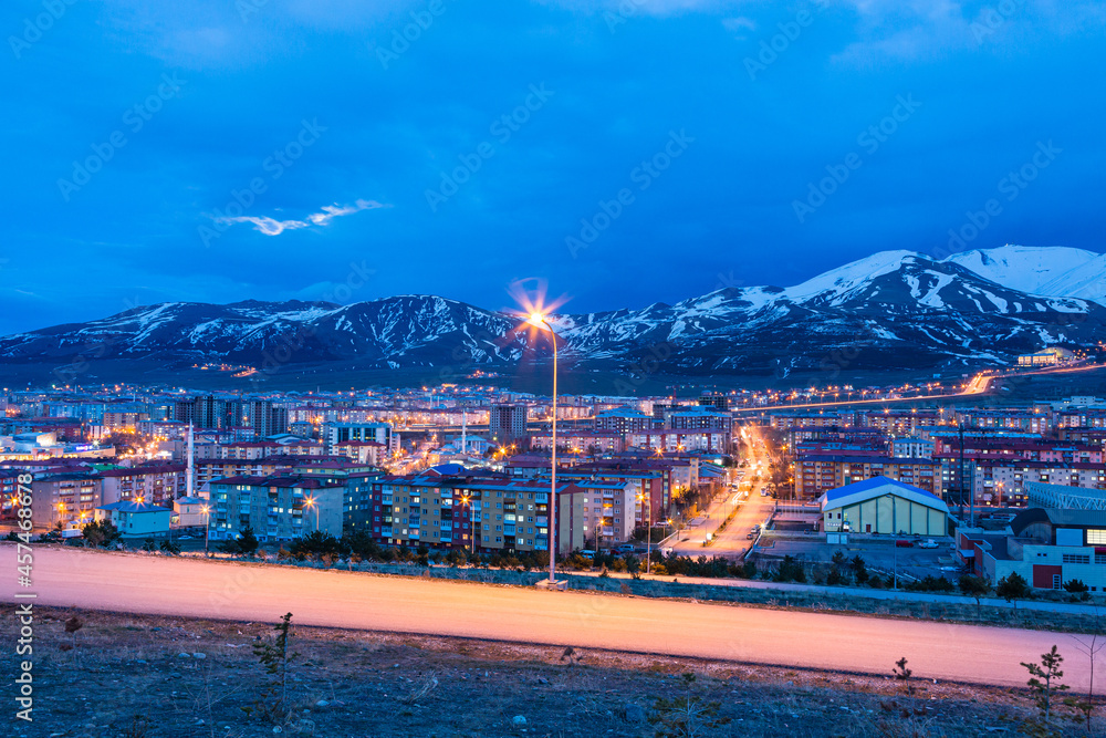 Obraz premium トルコ エルズルムの丘から見える夜景と雪の積もったパランドケン山