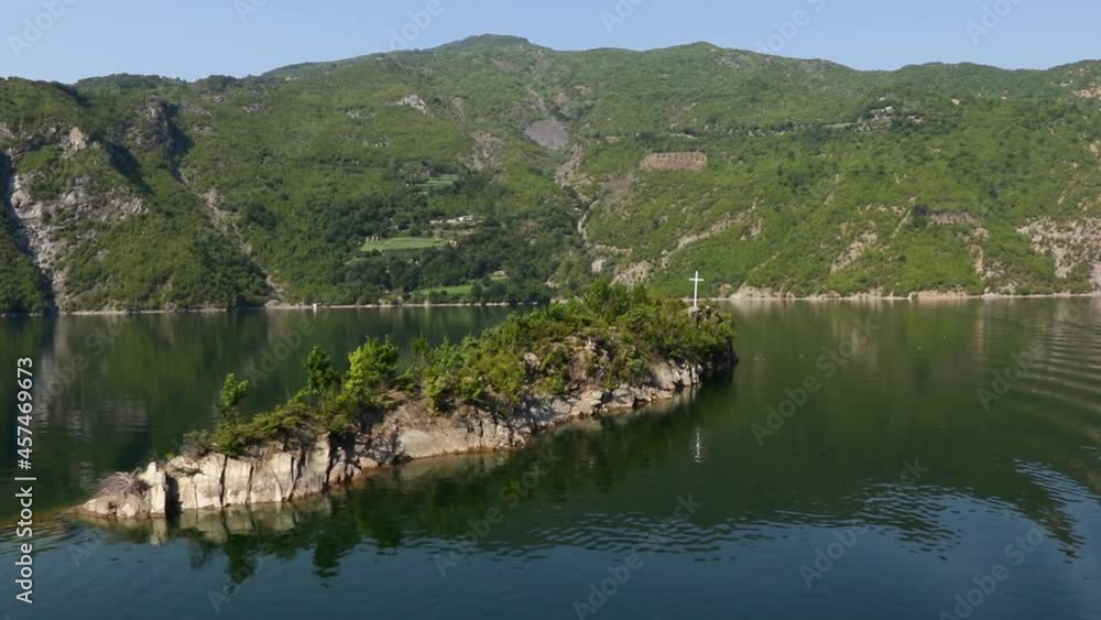 Rocky tiny island on Koman lake, beautiful ferry journey on Albanian mountains Rocky tiny island on Koman lake, beautiful ferry journey on Albanian mountains