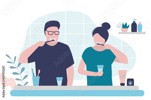 Couple brushing teeth in bathroom. Man and woman practice oral hygiene. Girl and guy do morning routine together