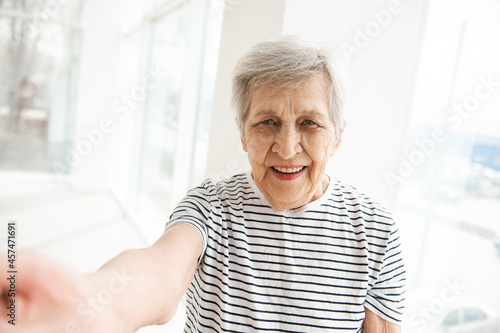 A beautiful elderly woman is talking on a video link.