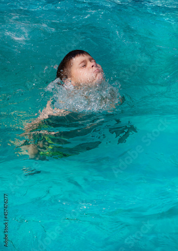 boy swimming in blue swimming pool