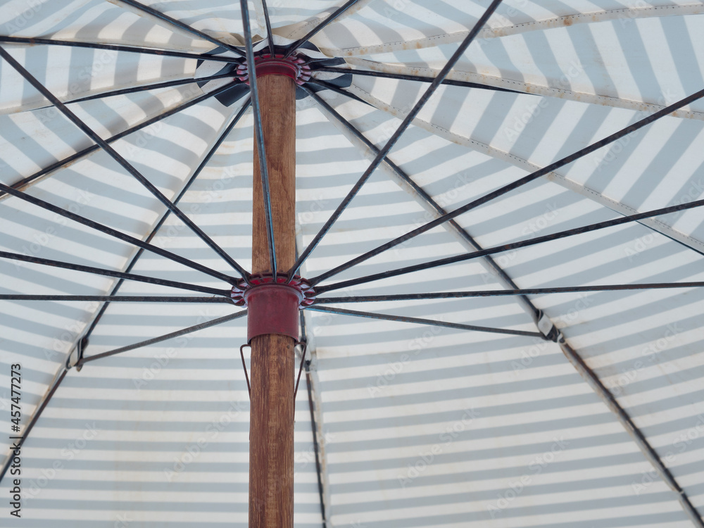 Obraz premium Under a large umbrella for relax during the summer holidays. Large umbrella protection from the sun or rain.