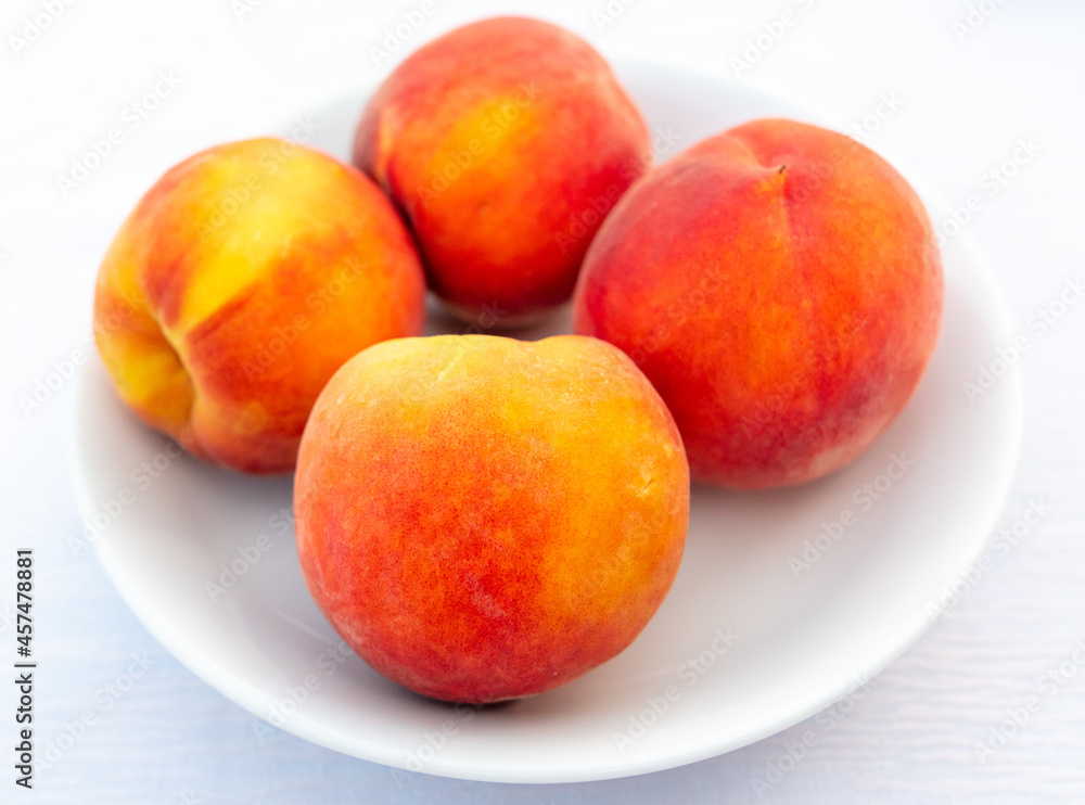 Ripe peaches in a white plate on the table. Ripe peaches in a white plate on the table.