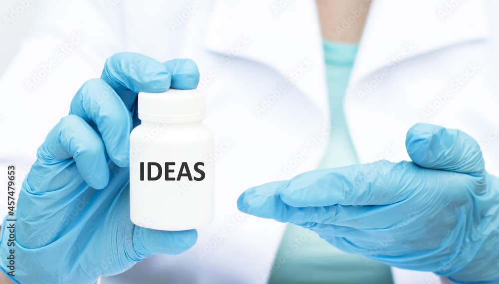 the hands of a gloved doctor hold a jar with the inscription Ideas close-up. the hands of a gloved doctor hold a jar with the inscription Ideas close-up.