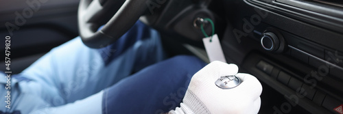 Male repairman in protective gloves holding steering wheel in car closeup