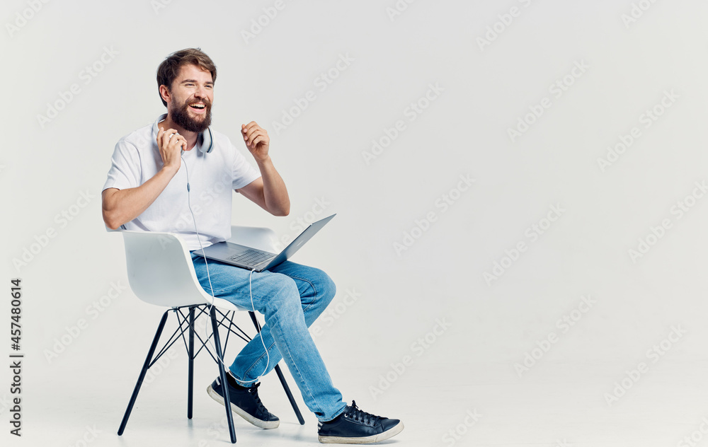bearded man sitting on a chair with a laptop on his lap technology bearded man sitting on a chair with a laptop on his lap technology