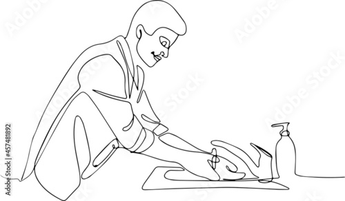 Unknown man cleaning his hands under the tap. He is wearing black clothes. He is in the kitchen. Young man washing hands in a kitchen at home