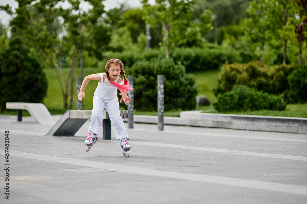 Cute little child girl on roller skates