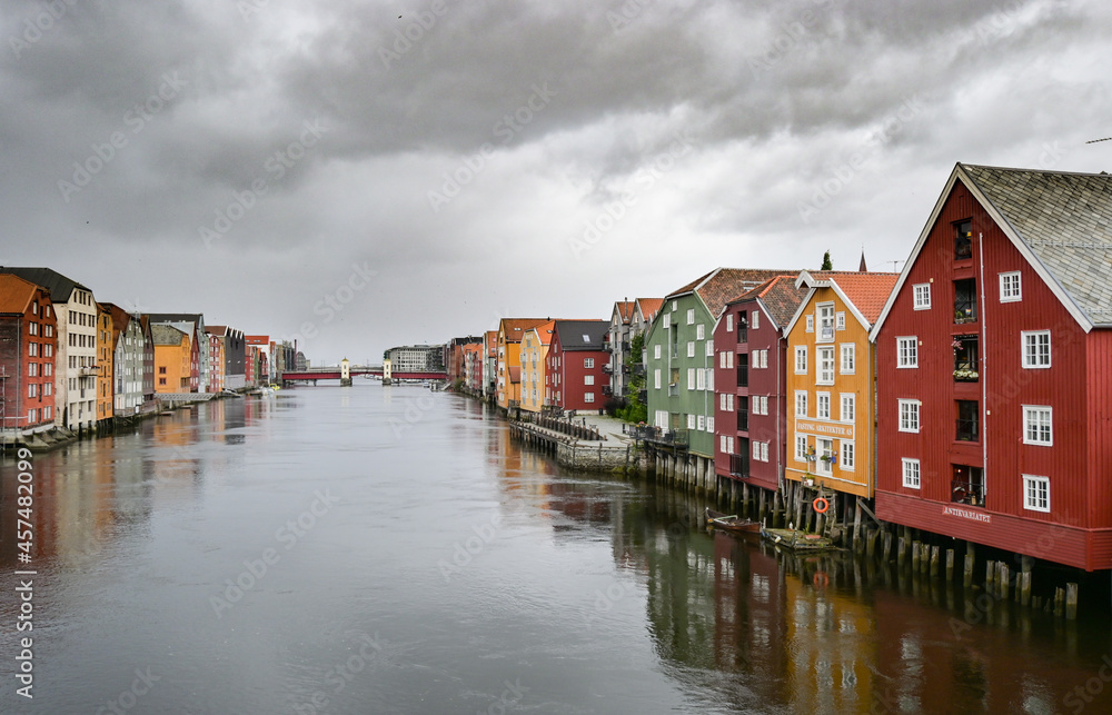 Typical colorful scandinavian buildings on a river in Trondheim in a cloudy rainy day