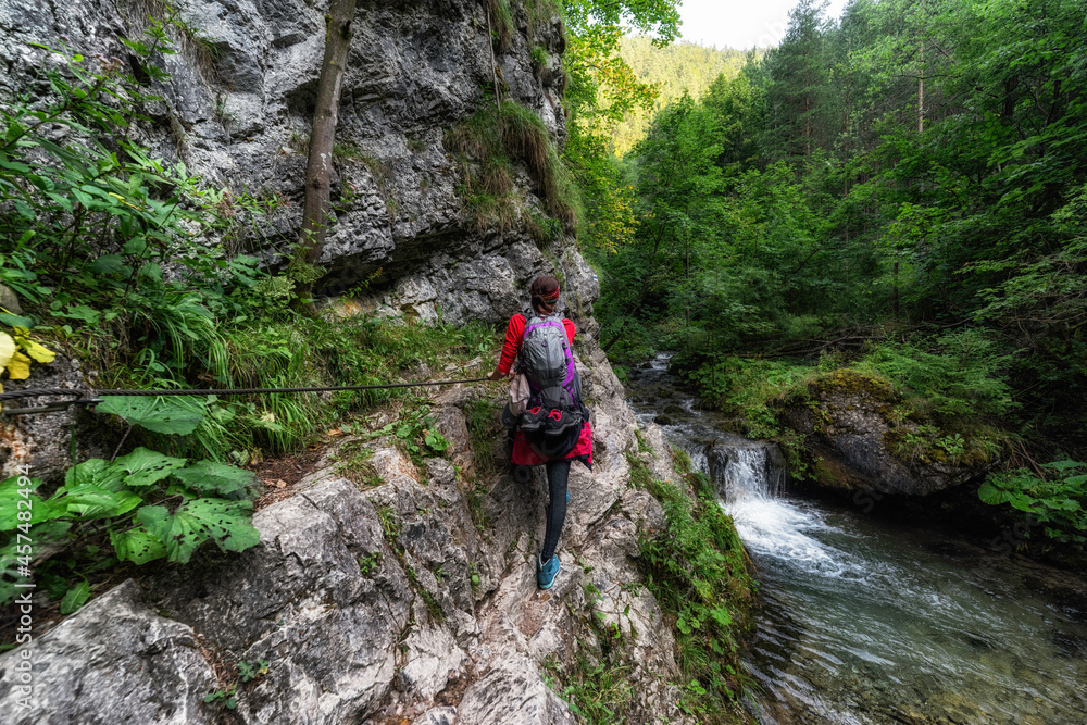 Female hiker on hiking trail in rocky canyon. Prosiecka valley in Slovakia Female hiker on hiking trail in rocky canyon. Prosiecka valley in Slovakia