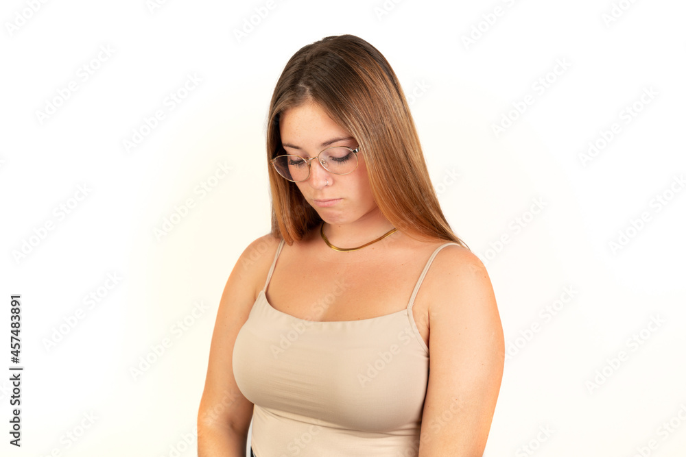 Sad blonde woman looking down. White background. 20 - 22 years old. White European woman. Sad blonde woman looking down. White background. 20 - 22 years old. White European woman.